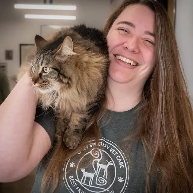 Megan smiling with a cat on her shoulder